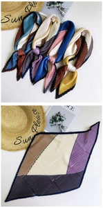 Detailed view of pleated silk neck scarves with geometric color blocking and soft textures