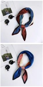 Detail of pleated square silk scarf in navy blue, beige, and pink patchwork patterns