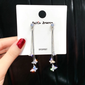 Macro shot of sparkling S925 silver long butterfly earrings with zirconia tassels