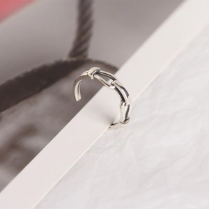 Detail of silver chain ear clip on card, minimalist interlocking links in high polish