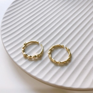 Minimalist 925 sterling silver gold rings with rope and chain texture on a ceramic plate