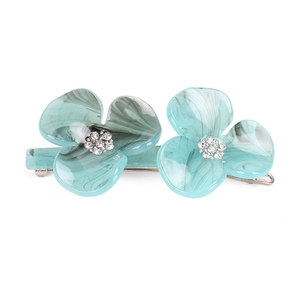 Detail of blue petal hair clip with marble texture and rhinestone centers