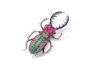 Gros plan d'une broche scarabée avec des strass colorés et finition argentée