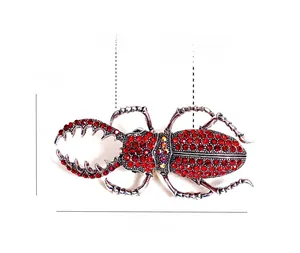 Vue détaillée de la broche scarabée en strass rouges luxueuse avec dimensions 7,5x3,8cm