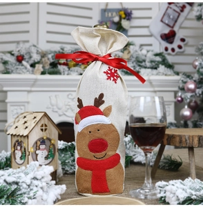 Close-up of burlap Christmas wine bottle cover with reindeer felt applique and festive ribbon
