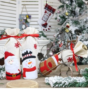 Detail of Christmas wine bottle covers with Santa and deer in festive linen fabric