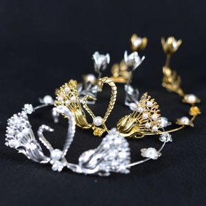 Elegant gold and silver swan bridal crowns with pearls on a professional black background