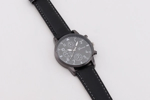 Detail einer minimalistischen Herren-Quarzuhr mit schwarzem Zifferblatt und Lederarmband