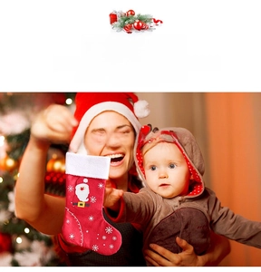 Detailed view of red felt Christmas stocking with Santa Claus embroidery by a Xmas tree