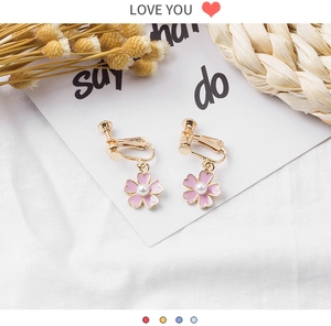 Detail of pink enamel cherry blossom clip-on earrings with white pearl and gold screw back