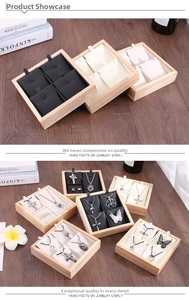 Detail view of square bamboo jewelry trays with black, grey, and white interior inserts