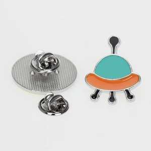 Detail of cartoon UFO enamel pin with mint green top and silver butterfly clutch back