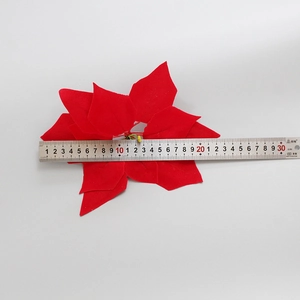 Detail view of 22cm red velvet artificial poinsettia showing diameter measurement with ruler