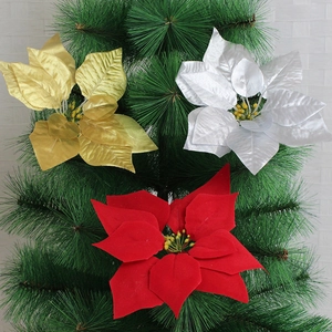 Close-up of red, gold, and silver poinsettia flowers on a Christmas pine tree background