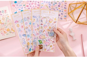 Detailed close-up of gold foiled unicorn and ocean theme stickers for DIY journals