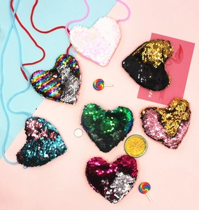 Macro shot of colorful heart-shaped sequin shoulder bags for kids in various shades
