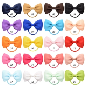 Flat lay of 20 multicolor grosgrain ribbon bow hair ties organized in a grid pattern