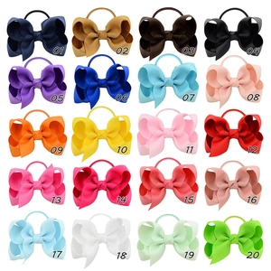 Flat lay of 20 assorted colors of grograin ribbon bow hair ties with elastic bands