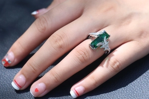 Elegant emerald-cut rainbow stone ring with hollowed leaf silver band on model hand