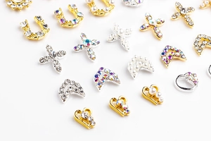 Detailed view of alloy nail art charms with pearls, crosses, and hearts in gold and silver