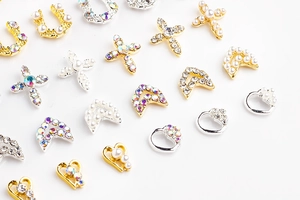 Detailed view of alloy nail art charms with pearls, rhinestones and cross heart designs
