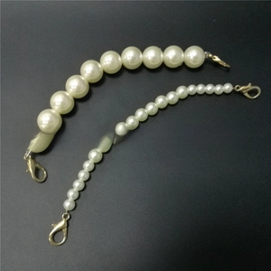 Close-up of artificial pearl bag chains in two sizes with gold lobster clasps