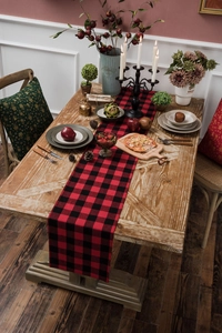 Detail of red and black checkered table runner with festive holiday decor and warm lighting