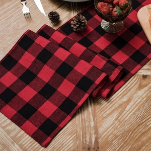 Christmas red and black buffalo plaid table runner on a rustic wooden table setup