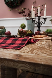 Close-up of red and black checkered table runner on a festive wooden Christmas table