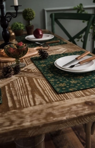 Detail of Christmas green table runner with golden snowflake foil printing on wood