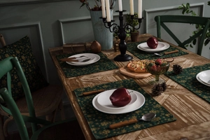 Detailed close-up of dark green table runner with gold Christmas snowflake patterns
