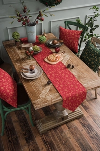 Close-up of red Christmas table runner with golden snowflakes and festive pillows
