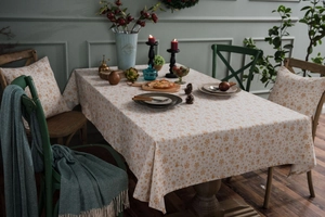 Close-up of festive tablecloth with gold snowflake patterns and matching pillow cover