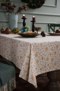 Detail of Christmas tablecloth showing linen texture and golden bell patterns