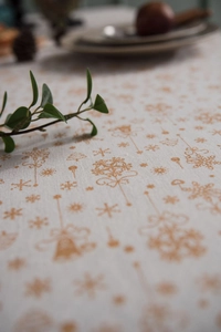 Detailed macro view of festive gold Christmas tree and snowflake patterns on linen fabric