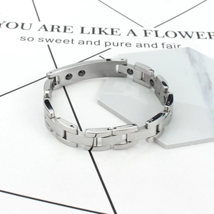 Polished silver magnetic therapy titanium steel link bracelet on marble stand