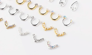 Makroansicht von gebogenen Smiley-Nägel-Charms mit Strass und Perlen auf Metall