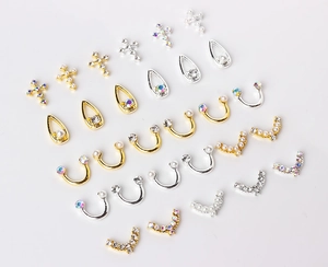 Detailliertes Set aus goldenen und silbernen Nagelcharms mit Perlen und Strasssteinen