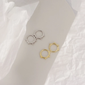 Detail view of gold and silver S925 sterling silver hoop earrings with bead accents