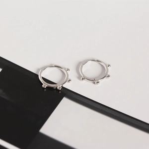 Detailed close-up of S925 sterling silver hoop earrings with textured bead accents