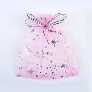 Detailed view of pink organza gift bag with silver moon and star prints and ribbon bow