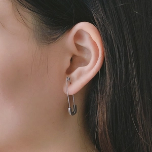 Minimalist 925 sterling silver safety pin earrings shown on model ear for women