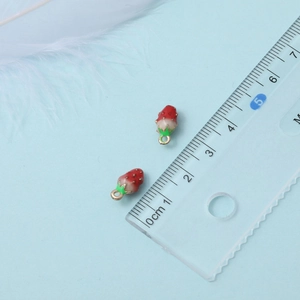 Detailed view of 3D strawberry charms next to a ruler showing 1cm scale size