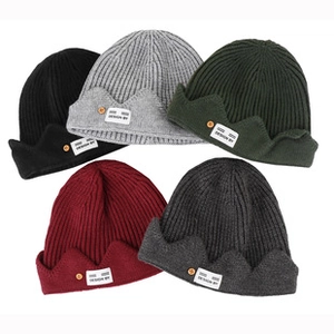 Vue détaillée de bonnets en tricot noirs, gris, verts et rouges avec revers côtelé