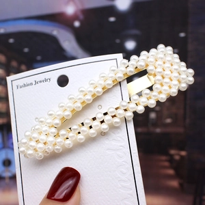 Detailed view of pearl hair clip with gold metal base on a Fashion Jewelry card