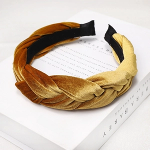 Close-up of golden and caramel brown velvet braided headband on decorative books