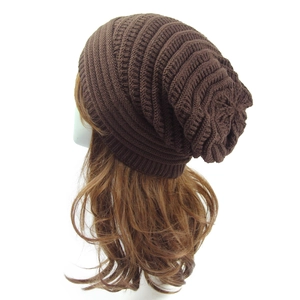Close-up of dark brown knitted beanie showing intricate twill texture and warm fabric