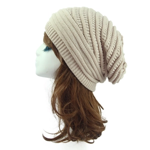 Detail view of beige chunky knit beanie on mannequin showing texture and slouchy design