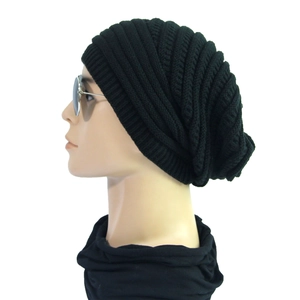 Detailed side view of black ribbed knit slouchy beanie with wave patterns and sunglasses