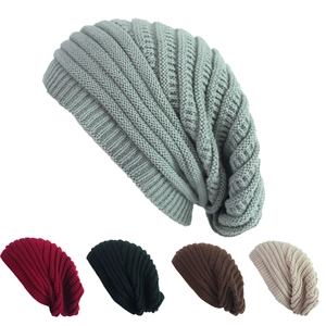 Detail view of multi-color knit beanies showing ribbed texture in gray, red, and black